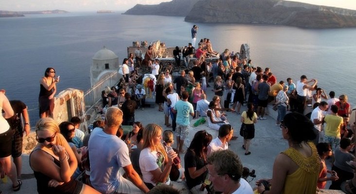 Turistas apreciando el atardecer en Santorini