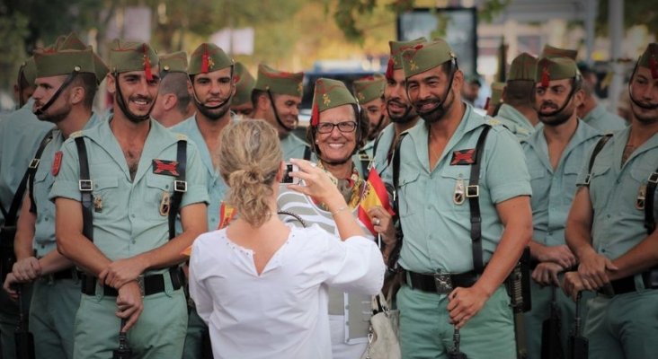 Una mujer se fotografía junto a los legionarios en el desfile del 12 de octubre