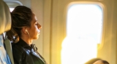 Pasajera usando auriculares en el avión