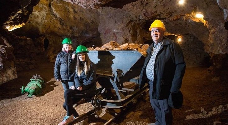 Un antiguo trabajador de la mina junto a su nieta Marta Bellés y Sandy, ambas guías