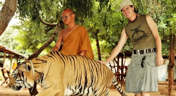 Una turista se hace una foto con un tigre. Foto de Gizmodo
