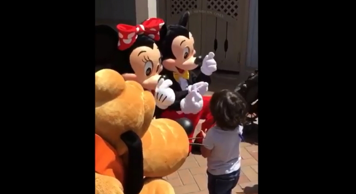 Minnie abraza a un niño y le dice que lo quiere en lenguaje de signos. Foto de Youtube