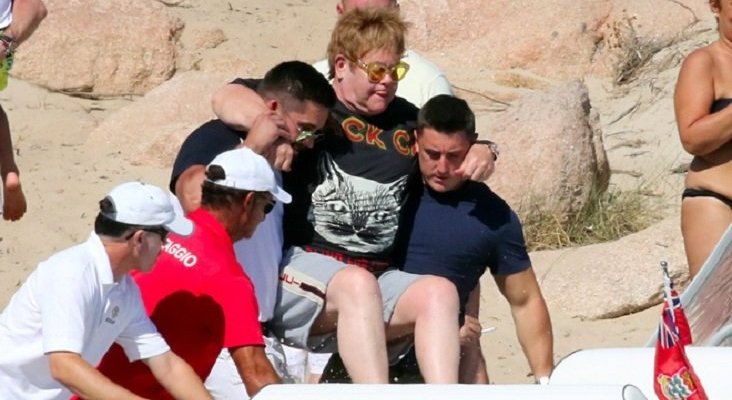 Elton John, cogido en volandas por sus guardaespaldas para no mojarse los pies|Foto: MEGA/ GTRES
