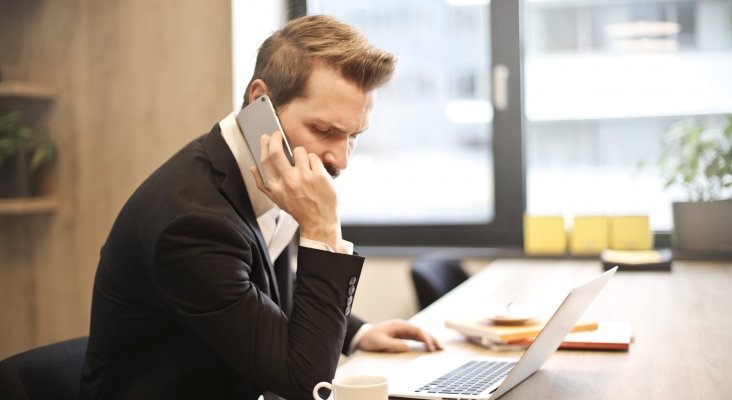man having a phone call in front of a laptop 859264 man having a phone call in front of a laptop 859264