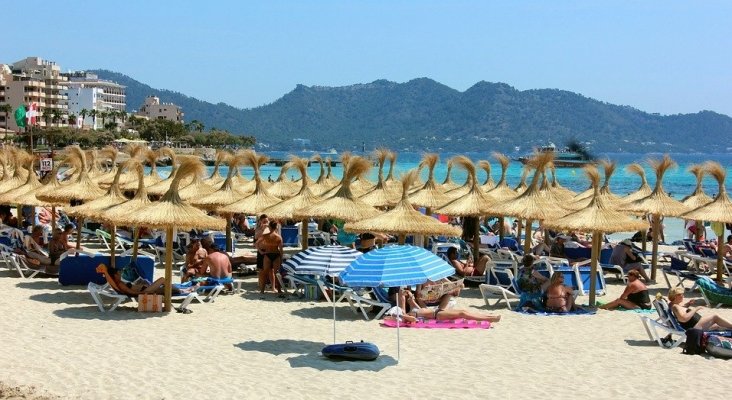 El 67,8% de los españoles prefiere veranear en España | Playa en Mallorca llena de turistas