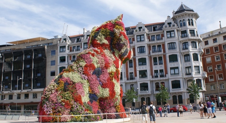 Paseantes bajo la figura de Puppy en Bilbao Paseantes bajo la figura de Puppy en Bilbao