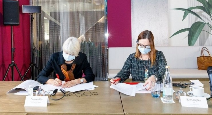 Carmen Riu y Sue Longley firmando el acuerdo