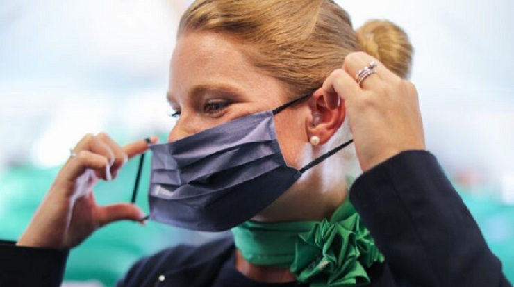 Azafata de Transavia colocándose la mascarilla
