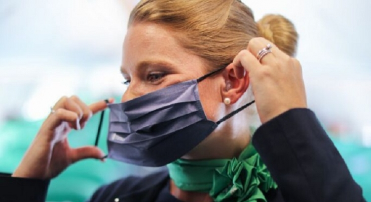 Azafata de Transavia colocándose la mascarilla