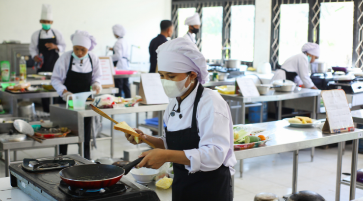 Cocineros en una formación, acompañados por el Chef