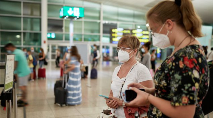 Pasajeros con mascarilla en aeropuerto español | Foto vía CDC