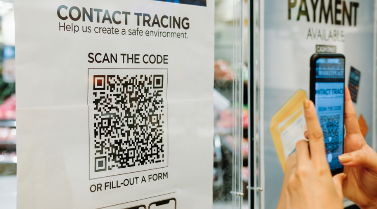 Persona escanea código QR en el escaparate de un establecimiento Persona escanea código QR en el escaparate de un establecimiento