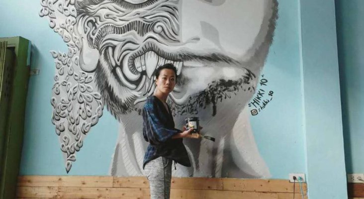 Se ofrece alojamiento a cambio de creatividad | Luanna Lee junto a una de sus obras en un albergue en Bangkok