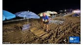 Hombre colocando una esterilla en primera línea de orilla de la playa de Benidorm (Alicante) cuando todavía es de noche | Fuente: Daily Mail