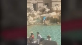 Graban a turista incívica subiéndose a la Fontana de Trevi (Roma) para llenar su botella de agua