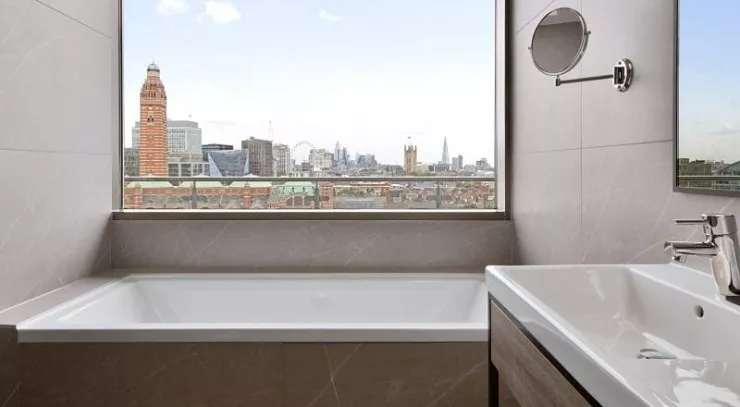 Baño de la habitación Presidential Suite en el hotel Riu Plaza London Victoria con vistas a Victoria Station y otros puntos emblemáticos de Londres