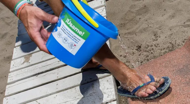 Persona lavándose los pies con agua del mar | Foto: Ayto. Torremolinos Persona lavándose los pies con agua del mar | Foto: Ayto. Torremolinos