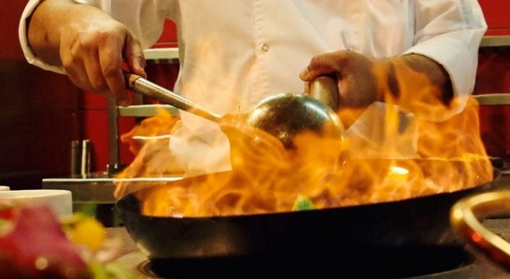 Cocinero preparando un plato en el momento dentro de un restaurante del hotel Riu Dubai, que opera en régimen Todo Incluido