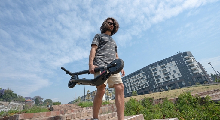 Viandante cargando un patinete eléctrico plegado | Foto: Mearth Technology (CC)