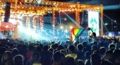 Joven enseñando la bandera lgtbi durante un evento